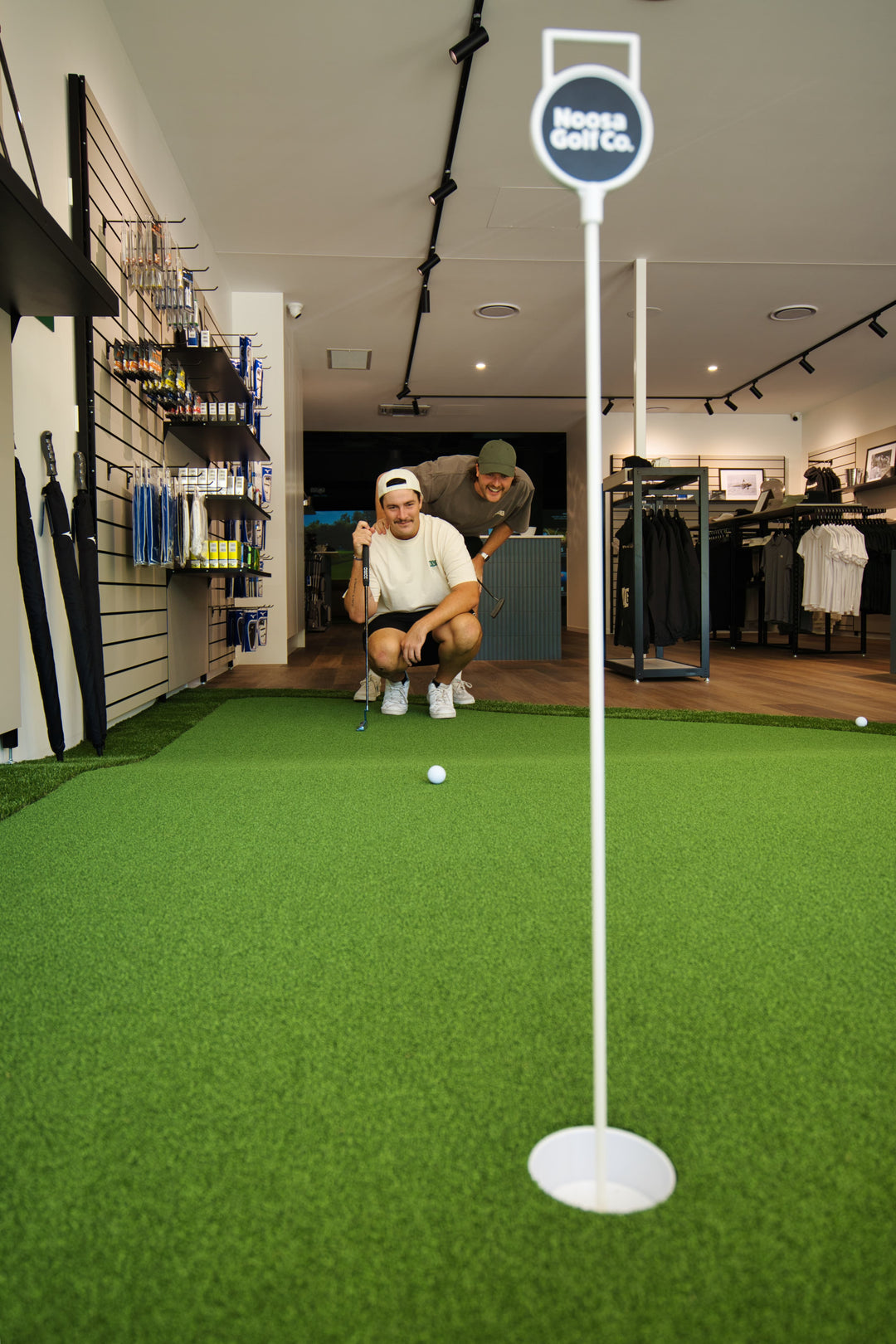 Golfers practicing putting during a PGA professional lesson at Noosa Golf Co. A premium Sunshine Coast golf shop with in-store coaching, indoor training, and expert guidance.