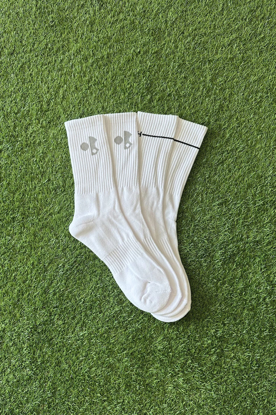 White Gray + Haast performance golf socks, designed for comfort and breathability. Shown on turf, perfect for golfers seeking premium socks on the Sunshine Coast.