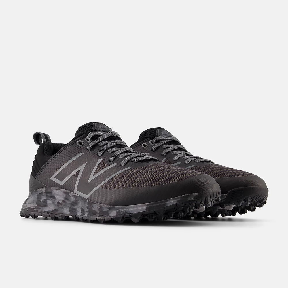 Angled view of a pair of New Balance golf shoes in black/grey camo. Designed for traction and comfort, perfect for Noosa golf courses.

